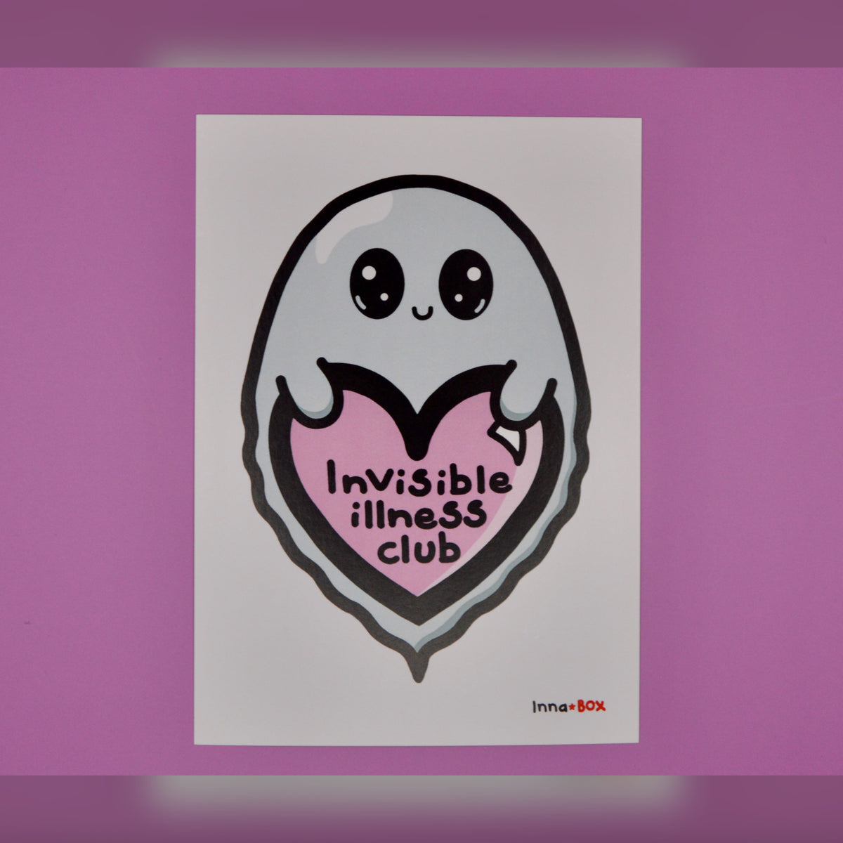 A white rectangular art print featuring a cute ghost-like character with large eyes, holding a pink heart that reads 'Invisible illness club' in black text. The print is centered on a solid pink background.