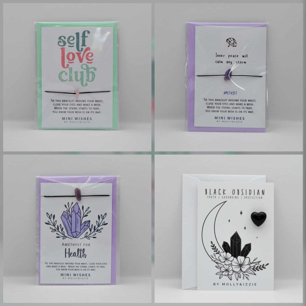 Four packaged card sets arranged in a 2x2 grid on a light gray background. The sets include pastel green, lavender, and white cards with mystical and astrological designs, including crystals, stars, and text such as 'self love club,' 'inner peace will calm any storm,' 'Amethyst for Health,' and 'Grounding Black Obsidian'.